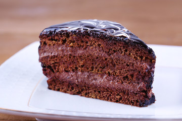 Delicious chocolate cake on plate on table close-up