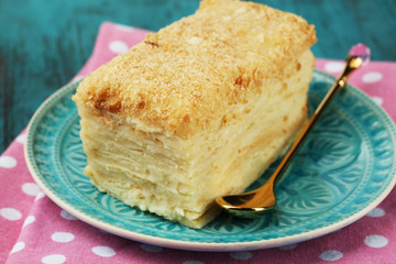 Napoleon cake on plate on table close-up