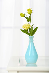 Beautiful bouquet of flowers in vase on window background