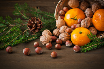 Christmas concept. Plate  with tangerine, cone and walnut
