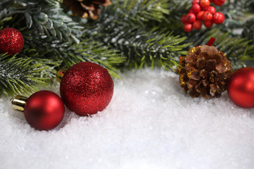 Obraz na płótnie Canvas Christmas composition with baubles and fir-tree on snow