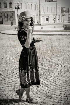 pretty woman in retro dress and hat drinking hot drink or  bever