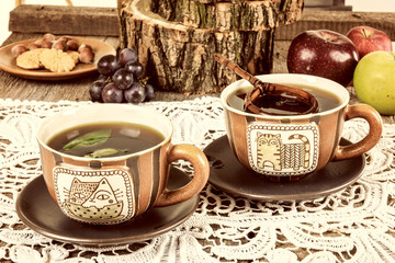 Tea cups with wooden strainer on dairy