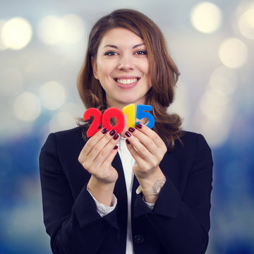 Happy business woman holding a figure of 2015.
