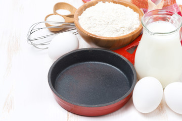 ingredients and frying pan for a batch of pancakes, horizontal