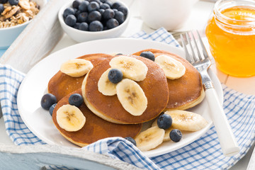 pancakes with banana, honey and blueberries for breakfast