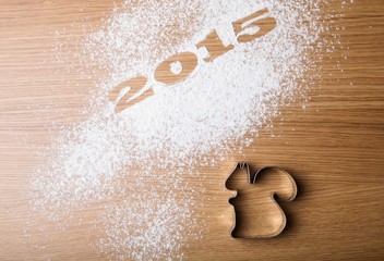 Inscription 2015 on flour and squirrel on a wooden table