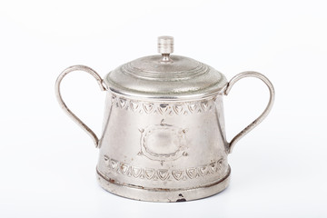 old sugar bowl with lid and spoon with spots of rust on a white
