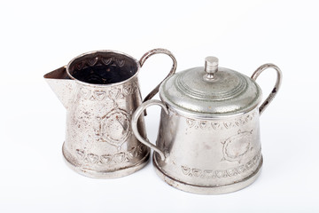 old sugar bowl with lid and an old coffee pot with spots of rust