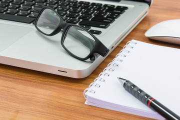 Blank business laptop, mouse, pen, note and glasses