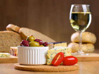 Blue cheese and olives on a wooden serving board