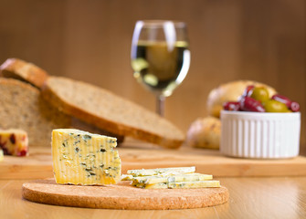 Blue cheese with glass of wine on a background