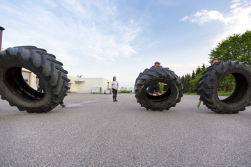 Fototapeta na wymiar Workout team flipping heavy tires outdoor