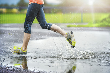 Girl of woman running in rainy weather - detail - obrazy, fototapety, plakaty