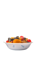 Mix variety of dried fruit in white bowl over white background
