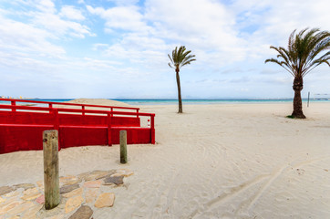 Red footbridge on sandy Alcudia beach, Majorca island, Spain