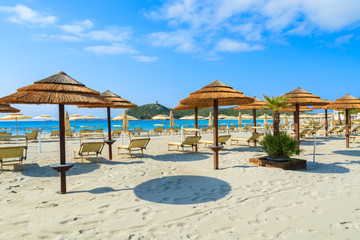 Sunchairs with umbrellas on Porto Giunco beach, Sardinia island