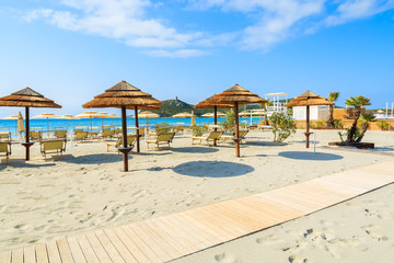 Sunchairs with umbrellas on Porto Giunco beach, Sardinia island