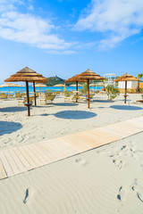 Sunchairs with umbrellas on Porto Giunco beach, Sardinia island