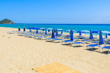 Wooden walkway and sunbeds on Cala Sinzias beach, Sardinia