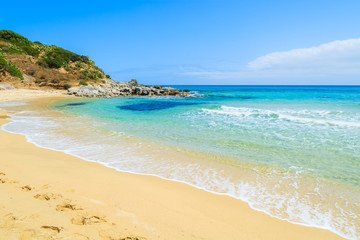 Footprints in sand on Cala Sizias beach and sea view, Sardinia