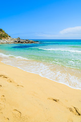 Footprints in sand on Cala Sizias beach and sea view, Sardinia
