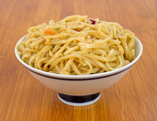 Chow Mein with shrimp in bowl on wood tabletop
