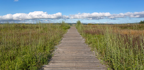 Obraz premium Old walkway towards blue cloudy sky