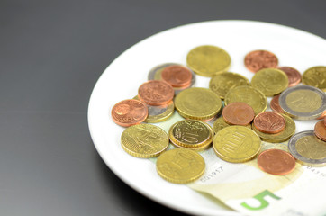 Münzen auf Teller