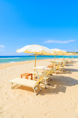 Sunbeds with umbrellas on Sa Colonia beach, Sardinia island