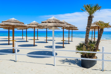 Sunbeds with umbrellas on Villasimius sandy beach, Sardinia