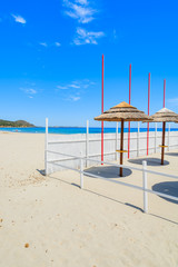Fototapeta premium Sunbeds with umbrellas on Villasimius sandy beach, Sardinia