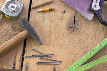 Old used carpentry tools on wooden background