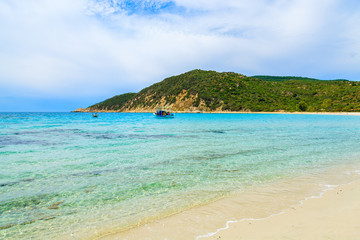 Fishing boat on turquoise sea water, Cala Pira, Sardinia island