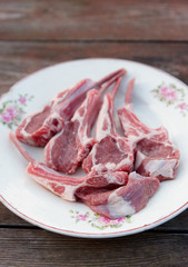 Raw rack of lamb on vintage plate