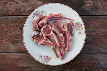 Raw rack of lamb on vintage plate
