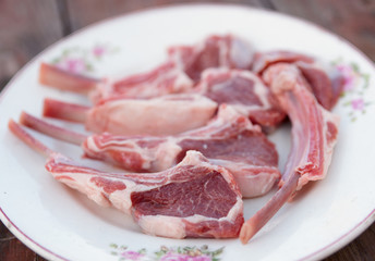 Raw rack of lamb on vintage plate