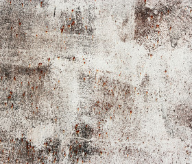 Rusty old metallic wall with white paint.