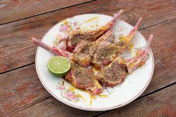 Raw rack of lamb on vintage plate