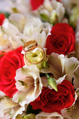 Gold wedding rings on a bouquet of flowers for the bride