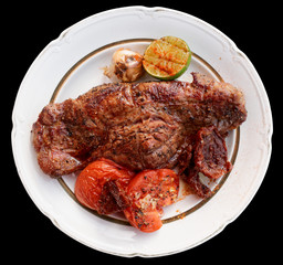 Striploin steak with grilled vegetables, black background