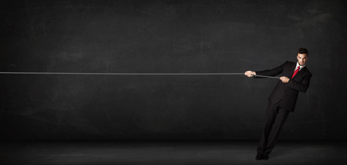 Businessman pulling rope on grey background © ra2 studio