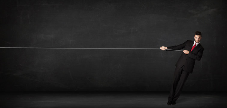 Businessman pulling rope on grey background