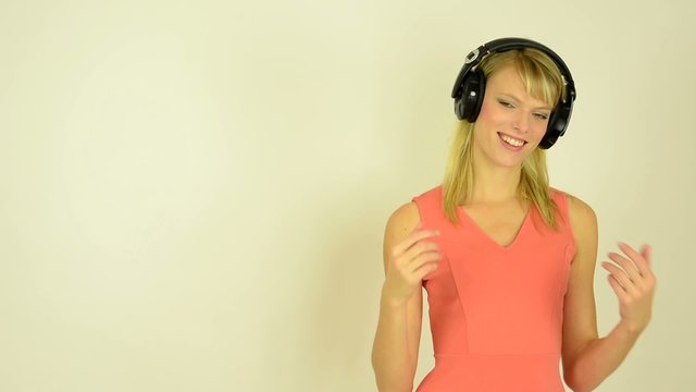 woman listens to music with headphones and woman welcomes