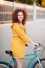 Fototapeta na wymiar Cute girl on a vintage bike in the city