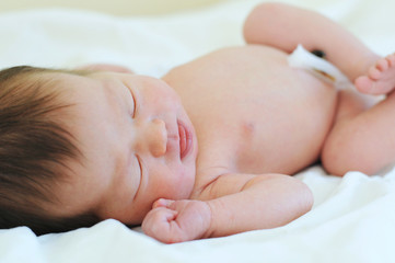 Newborn baby with umbilical cord sleeping