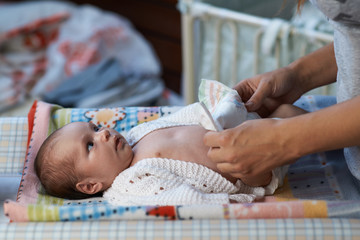 mom changing diapers newborn