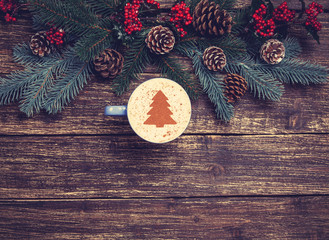Cup of coffee with cream christmas tree on a table.