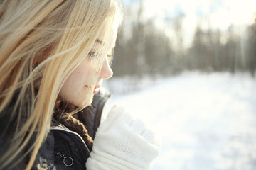 portrait of a young blonde girl in winter forest in the park
