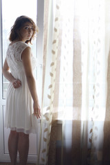 Fototapeta na wymiar girl standing at the window